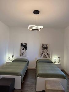 two beds in a room with portraits on the wall at Sweet Dreams Residence in Brugine +9 photos