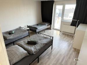 three beds in a room with a window at Monteurunterkunft in Raunheim in Raunheim