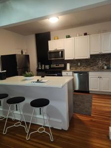 een keuken met witte kasten en een aanrecht met krukken bij Market Haven in Wilmington