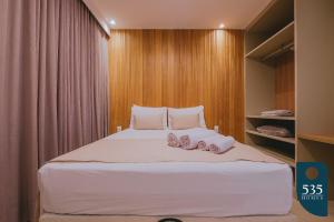 a bedroom with a bed with two pairs of slippers at Praia do Forte 2 bedrooms Complete and Comfortable in Mata de Sao Joao +38 photos
