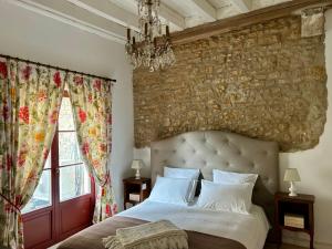 a bedroom with a large bed and a stone wall at La Grange à Grains - Château-Renard in Château-Renard