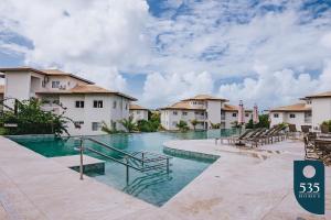 a swimming pool at a resort with buildings at Praia do Forte 2 bedrooms Complete and Comfortable in Mata de Sao Joao