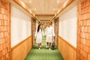 a man and a woman walking down a hallway at Landhaus Leopoldhof in St. Wolfgang