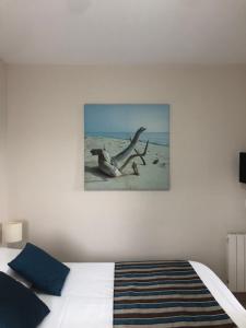 a bedroom with a bed and a picture on the wall at Hôtel Le Trécelin in Frehel +40 photos