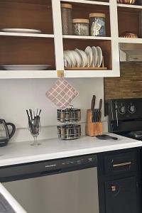a kitchen counter with a dishwasher and cabinets at Simply Home in Statesboro