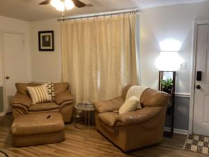 a living room with two chairs and a couch at Simply Home in Statesboro +18 photos