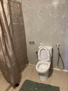 a bathroom with a toilet and a shower at Alone in Dakar