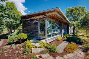 a tiny house with a large window in a garden at Rackliff Island Hideaway in Spruce Head