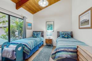 two beds in a room with a window at Sea Raven in Gualala