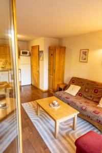 a living room with a bed and a coffee table at Bel Appartement lumineux au coeur de la station de Vars in Vars