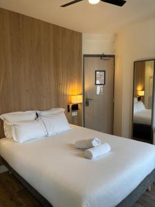 a large white bed with two folded towels on it at Korner République in Paris