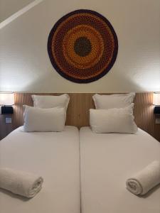 two beds with white sheets and a picture on the wall at Korner République in Paris
