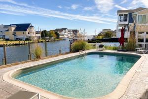 una gran piscina al lado de un cuerpo de agua en Keen-Wik on the Bay --- 38355 Hickory Ln, en Bayville