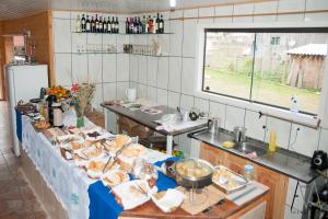 a kitchen with a table with food on it at Pousada Cristal Serra in Cambará