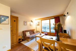 a living room with a couch and a table at Bel Appartement lumineux au coeur de la station de Vars in Vars