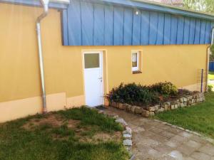 a yellow and blue building with a white door at Am Blauen See in Dabel