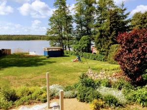a garden with a playground next to a lake at Am Blauen See in Dabel