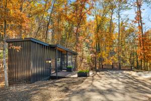 una casa nera nel bosco con alberi di A Place & Time a Lickskillet