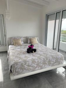 un orsacchiotto seduto su un letto in una camera da letto di Villa Bel'Horizon a Bielle