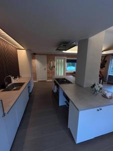 a large kitchen with white counters and a sink at Green Garden Oslo - Luxury Resort in Kolbotn