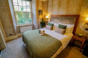 a bedroom with a bed with a teddy bear on it at The Cranleigh Boutique in Bowness-on-Windermere