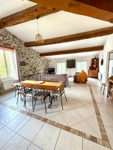 a living room with a wooden table and chairs at Gîte au cœur d un caveau de dégustation de vin in Olonzac