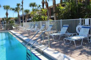 una piscina con sedie blu accanto a una recinzione di Blue Paradise a Englewood