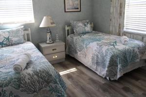 una camera da letto con due letti e un tavolo con una lampada di Blue Paradise a Englewood Altre 63 foto