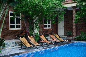 a group of chairs sitting next to a swimming pool at Cosiana Homestay in Ninh Binh