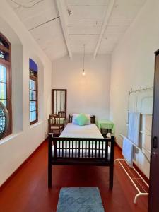 Un pat sau paturi într-o cameră la Mendila Heritage Hikkaduwa