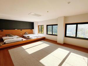two beds in a large room with windows at 苗場サンバレーホテル in Minami Uonuma +8 photos