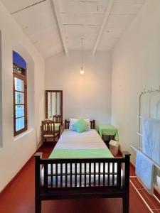 Un pat sau paturi într-o cameră la Mendila Heritage Hikkaduwa