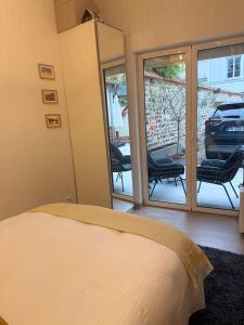 une chambre avec un lit et un balcon avec des chaises dans l'établissement Maison Marie Charme & confort à Rouen centre, à Rouen