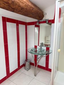 a glass table in a kitchen with red and white stripes at Gîte au cœur d un caveau de dégustation de vin in Olonzac +8 photos