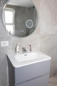 a bathroom with a white sink and a mirror at 3 Min To Center Stylish Stay's in Tirana