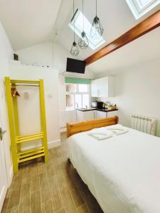 a bedroom with a white bed and a kitchen at Kings' House in Douglas
