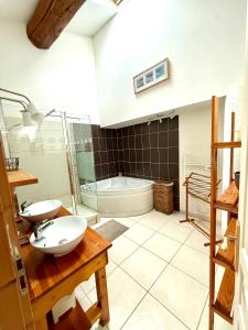 a bathroom with two sinks and a bath tub at Gîte au cœur d un caveau de dégustation de vin in Olonzac