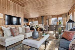 ein Wohnzimmer mit zwei Sofas und einem Fernseher in der Unterkunft Large family cabin at Hafjell with ski in-ski out in Hunder
