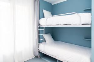 twee stapelbedden in een kamer met een raam bij OLDEGAR Hôtel in Nantes