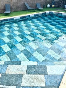 a swimming pool with blue and white tiles on it at Gîte au cœur d un caveau de dégustation de vin in Olonzac