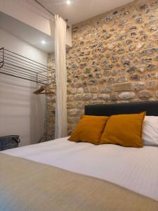une chambre avec un mur en pierre et un lit dans l'établissement Maison Marie Charme & confort à Rouen centre, à Rouen