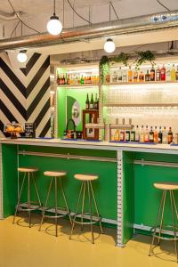 een groene bar met krukken in een kamer bij OLDEGAR Hôtel in Nantes