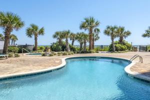 a swimming pool with palm trees in the background at Palace Resort in Myrtle Beach
