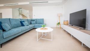un soggiorno con un divano blu e una TV di Villa Sapphire 62 a Castillo de Sabinillas