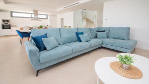 un divano blu in un soggiorno con un tavolo di Villa Sapphire 62 a Castillo de Sabinillas