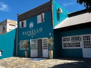a blue building with white doors and a sign at RAFAELLO HOTEL in São Borja