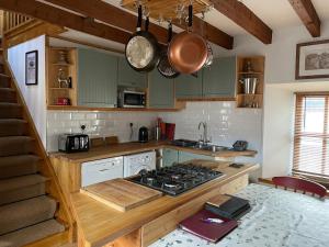 a kitchen with green cabinets and a stove top oven at Culrain Cottage in Fort Augustus