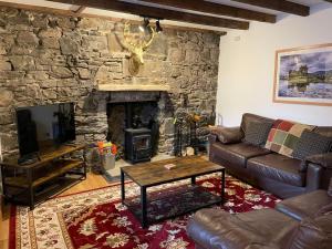 un soggiorno con divano e camino di Culrain Cottage a Fort Augustus