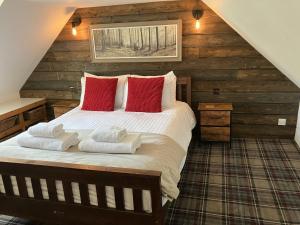 una camera da letto con un letto grande con cuscini rossi di Culrain Cottage a Fort Augustus