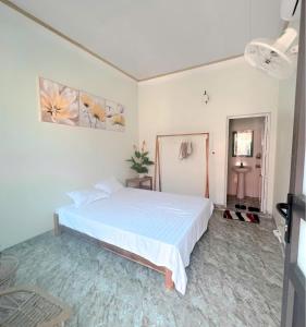 een slaapkamer met een wit bed in een kamer bij Homestay Suối Mây Garden in Kon Rung (1)